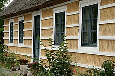 Reethaus mit weißem Holzgitter Reethaus mit weißem Holzgitter