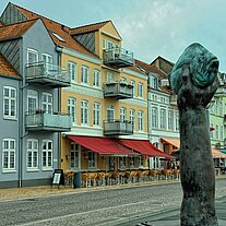Hafenbauten und Fischskulptur